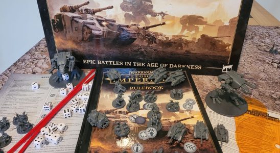 The Legions Imperialis box, rulebook, miniatures, tokens, and tools on a table