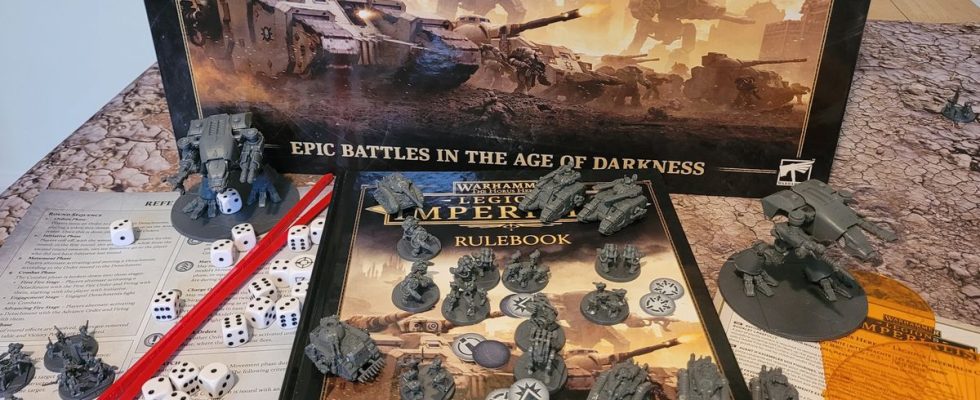The Legions Imperialis box, rulebook, miniatures, tokens, and tools on a table