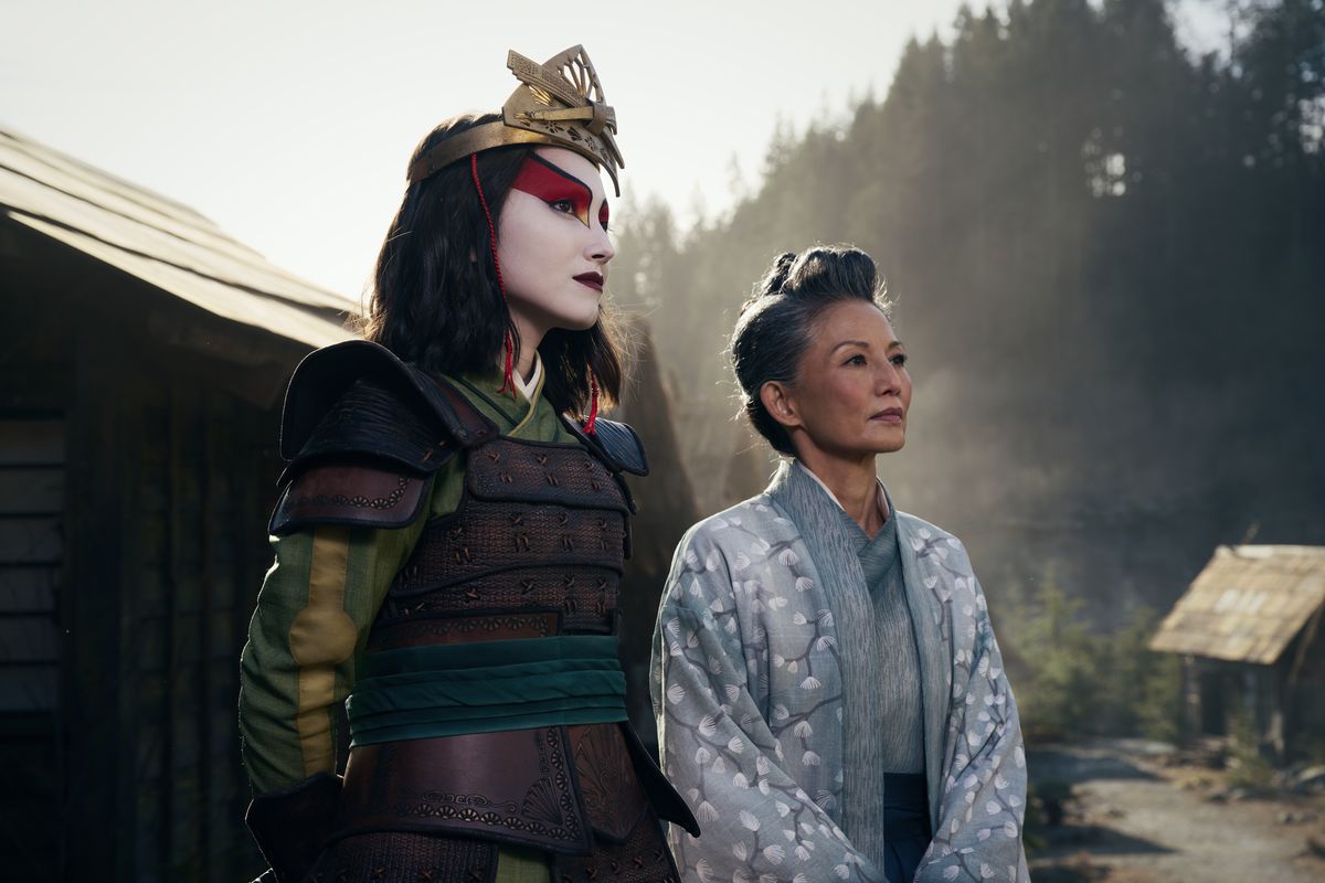 Suki de la version live-action d'Avatar : Le dernier maître de l'air en tenue complète de Kyoshi Warrior, debout à côté du maire Yukari