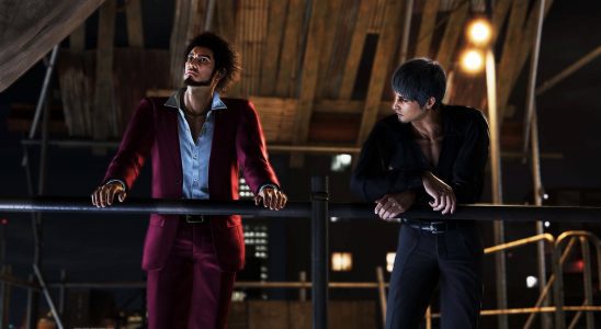 Image of Ichiban and Kiryu leaning on a metal railing overlooking the city at night and talking in Like a Dragon: Infinite Wealth.