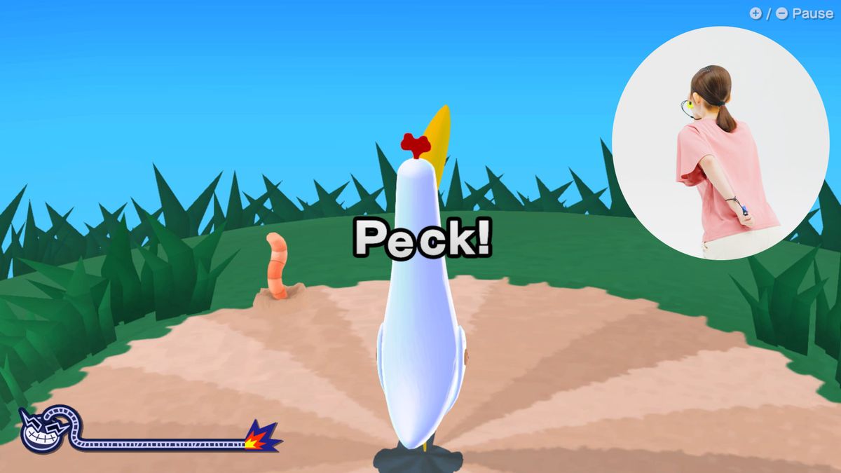 Une capture d'écran de WarioWare : Move It !  avec un oiseau au centre de l'écran, l'invite « Peck ! »  et un ver de terre sortant du sol