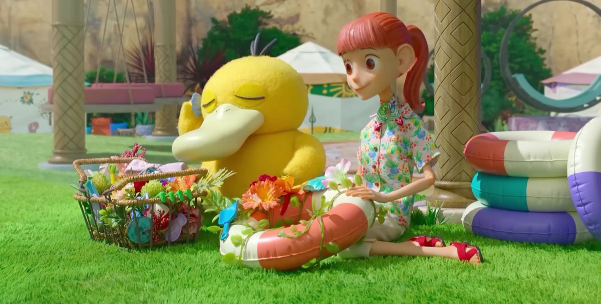 Une image tirée de l'émission d'animation stop Pokémon Concierge.  Il montre Haru et Pysduck assis dehors et décorant des flotteurs.  Le Pysduck ferme les yeux et essaie d'écouter un son dans la coquille.