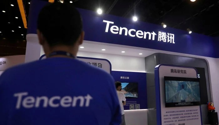 Un employé se tient devant le magasin Tencent.