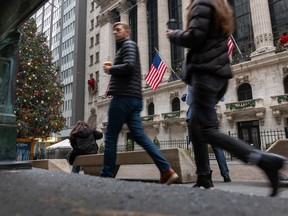 Les gens passent devant la Bourse de New York le 26 décembre. Les investisseurs sont pleins d'optimisme pour 2024 alors que l'indice S&P 500 se situe à proximité de son premier sommet historique en près de deux ans.