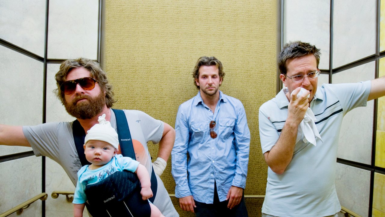 Zach Galifianakis dans le rôle d'Alan (tenant le bébé), Bradley Cooper dans le rôle de Phil et Ed Helms dans le rôle de Stu dans l'ascenseur dans The Hangover