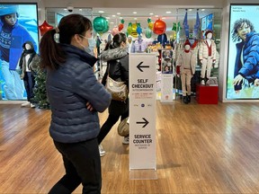 Un panneau indiquant aux acheteurs les caisses automatiques est affiché dans un magasin de New York le mercredi 6 décembre 2023.