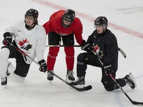 Conor Geekie (28 ans), Macklin Celebrini (17 ans) et Denton Mateychuk (24 ans) du Canada écoutent les instructions pendant l'entraînement à l'aréna Scandinavium avant le début du Championnat mondial de hockey junior de l'IIHF à Göteborg, en Suède, le lundi 25 décembre 2023. Le Canada affrontera la Finlande lors de son premier match le 26 décembre.