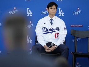 Shohei Ohtani des Dodgers de Los Angeles écoute les questions lors d'une conférence de presse sur le baseball au Dodger Stadium le jeudi 14 décembre 2023, à Los Angeles.