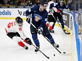 Matthew Poitras du Canada et Samu Bau de Finlande se disputent la rondelle lors du match de hockey sur glace du groupe A entre la Finlande et le Canada du Championnat mondial junior de l'IIHF à Göteborg, en Suède, le 26 décembre 2023.
