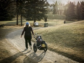 Un golfeur parcourt un chemin de charrette tout en jouant une partie au parcours de golf Shaganappi Point à Calgary, le mardi 5 décembre 2023.