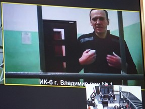 Un écran montre le critique emprisonné du Kremlin, Alexeï Navalny, alors qu'il arrive pour écouter une audience sur un appel déposé contre une décision de justice le condamnant à 19 ans de prison dans une prison à sécurité maximale pour des accusations liées à l'extrémisme, devant un tribunal de Moscou le 26 septembre. , 2023.