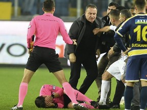 L'arbitre Halil Umut Meler se tient le visage alors qu'il est allongé au sol après avoir été frappé par le président du MKE Ankaragucu, Faruk Koca, au centre, à la fin du match de la Super Lig turque.