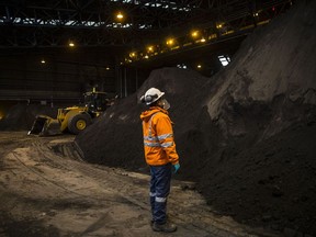 Un employé examine un tas de concentré de cuivre dans un entrepôt au Pérou.