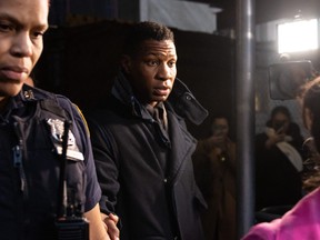 Jonathan Majors (au centre) quitte une salle d'audience après avoir été reconnu coupable d'agression et de harcèlement contre son ancienne petite amie, devant le tribunal pénal de Manhattan, à New York, le 18 décembre 2023.