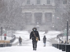 Une personne marche sur le campus de l’Université McGill lors de légères chutes de neige à Montréal le dimanche 20 décembre 2020.