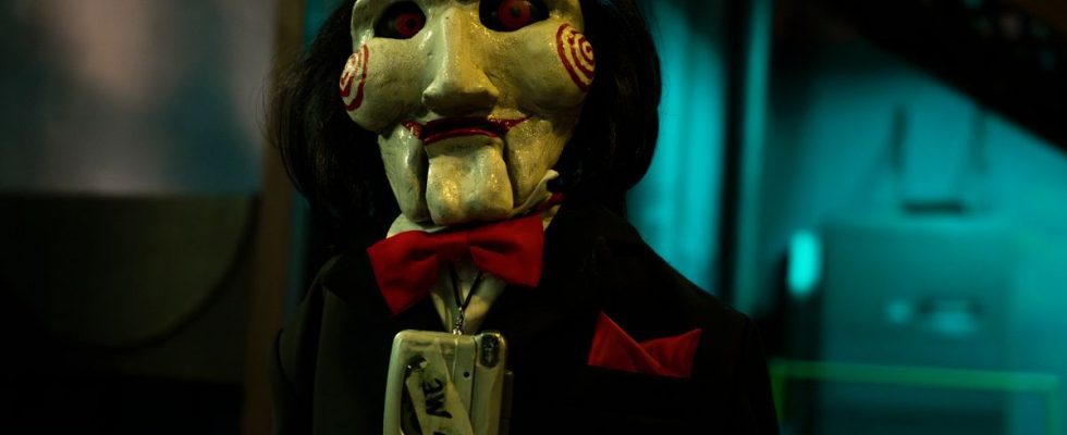 Billy the puppet, wearing a tape recorder around his neck, in Saw X.