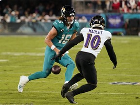 Le quarterback des Jacksonville Jaguars Trevor Lawrence fumble le ballon tandis que le cornerback des Baltimore Ravens Arthur Maulet (10) se rapproche.