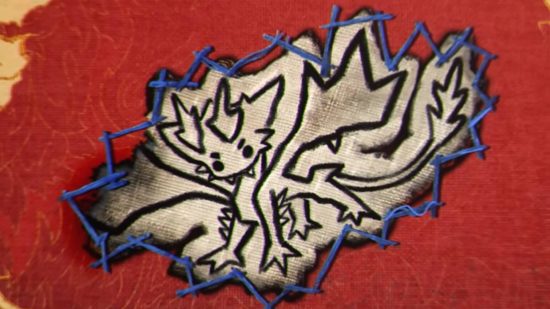 Un joli dessin d'une petite créature dragon cousu sur du tissu rouge