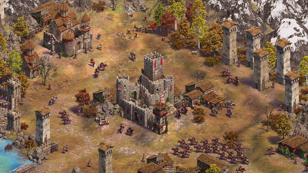 Une petite armée de cavalerie s'approche du château au centre d'une base dans l'extension Mountain Royals d'Age of Empires 2 : Definitive Edition.