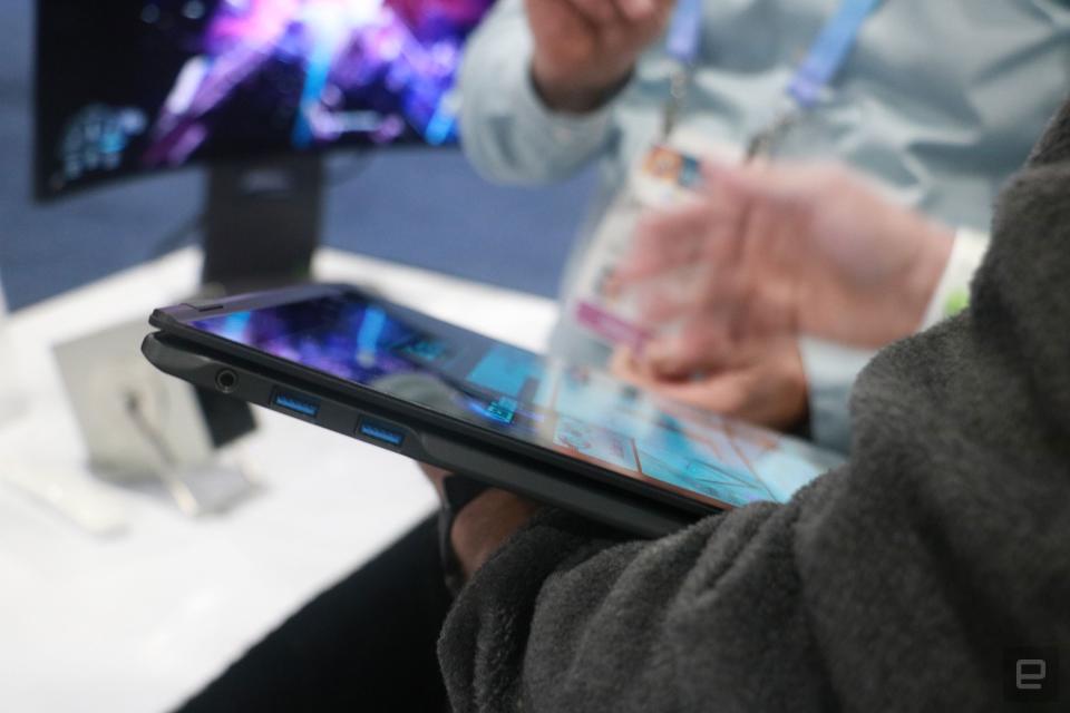 Le LG Gram Pro 2-en-1 plié avec son écran vers le haut, reposant sur le bras d'une personne tandis que l'autre main interagit avec l'écran.