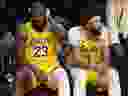 LeBron James des Los Angeles Lakers, à gauche, et Anthony Davis sont assis sur le banc.