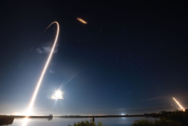 Cette photo en pose longue montre une fusée SpaceX Falcon Heavy se dirigeant vers l'espace depuis le centre spatial Kennedy de la NASA en Floride.  Quelques minutes plus tard, les propulseurs latéraux de la fusée sont revenus atterrir à la station spatiale de Cap Canaveral, à quelques kilomètres de là.