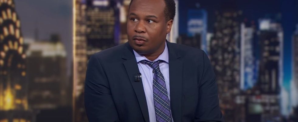 Roy Wood Jr. sitting at the main desk on The Daily Show.