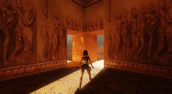 Tomb Raider: Lara Croft stood in a temple with light from a hallway shining through.