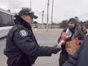 Une capture d'écran de la vidéo montre un policier de Toronto et un manifestant qui désigne ensuite la police comme étant 
