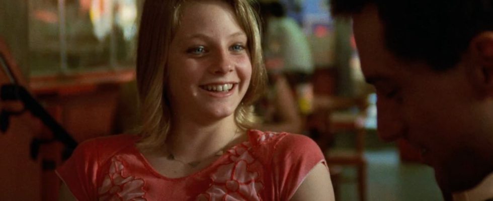 Jodie Foster laughs while talking at the table in Taxi Driver.
