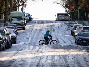Un cycliste traverse à vélo une colline glacée à Vancouver le vendredi 12 janvier 2024.