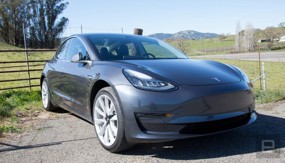 Tesla Model 3 assise sur une allée de campagne.