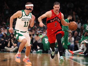 Goran Dragic des Raptors de Toronto dribble contre Payton Pritchard des Celtics de Boston lors du match d'ouverture à domicile des Celtics au TD Garden le 22 octobre 2021 à Boston.