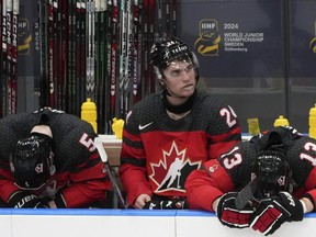Les joueurs canadiens (de gauche à droite) Oliver Bonk (5), Denton Mateychuk (24) et Maveric Lamoureux (13) réagissent après leur défaite contre la Tchéquie.