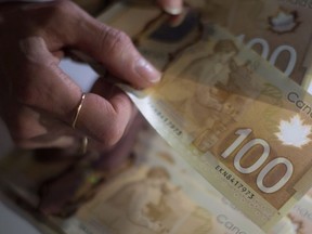 Les billets de 100 $ canadiens sont comptés à Toronto le mardi 2 février 2016.