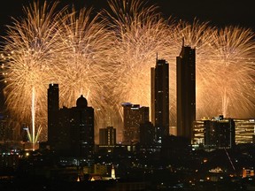 Des feux d'artifice explosent au-dessus des toits de la ville, le long du fleuve Chao Phraya, lors des célébrations du Nouvel An à Bangkok, le 1er janvier 2024.