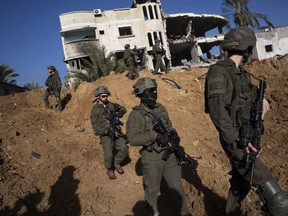 Des troupes de l'armée israélienne sont vues à côté d'un bâtiment détruit lors d'une opération terrestre à Khan Younis, dans la bande de Gaza, le mercredi 10 janvier 2024.