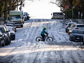 Les avertissements météorologiques couvrent une grande partie du Canada ce week-end, depuis les écoulements arctiques sur la côte de la Colombie-Britannique jusqu'au froid extrême dans les Prairies et aux tempêtes dans le sud de l'Ontario, du Québec et des Maritimes.  Un cycliste traverse à vélo une colline glacée à Vancouver le vendredi 12 janvier 2024.