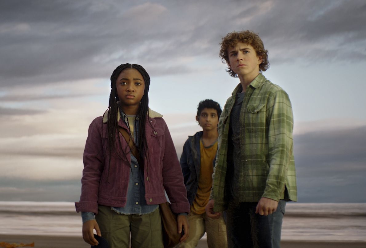 Percy (Walker Scobell), Annabeth (Leah Sava Jeffries) et Grover (Aryan Simhadri) debout sur une plage