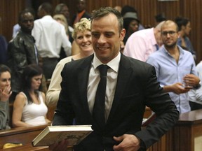 Oscar Pistorius, au centre, quitte une salle d'audience de la Haute Cour de Pretoria, en Afrique du Sud, en 2015.