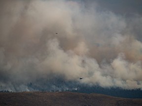 Des hélicoptères survolent l'incendie de forêt de Tremont Creek alors qu'il brûle sur les montagnes au-dessus d'Ashcroft, en Colombie-Britannique, le vendredi 16 juillet 2021.