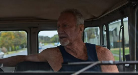 Slim, an older man in a tanktop, driving a truck