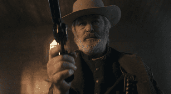 Alec Baldwin dressed in Western gear holds a Colt .45 in footage shot for "Rust."
