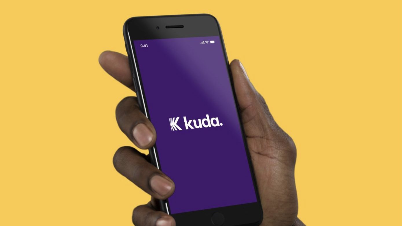 Main tenant un smartphone affichant le logo Kuda