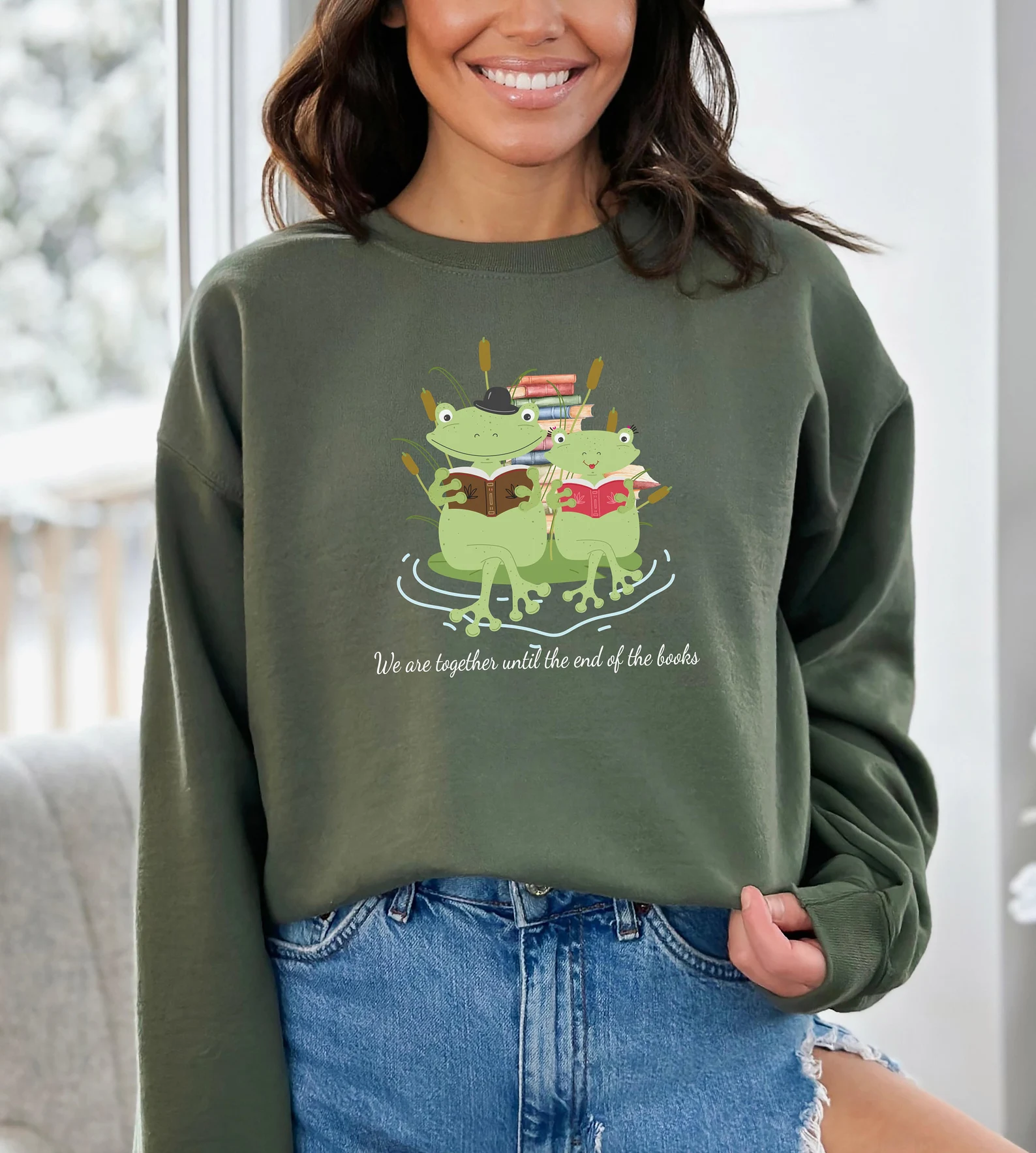 Image d'un sweat-shirt vert avec une image de deux grenouilles lisant une pile de livres.  Ça dit "nous sommes ensemble jusqu'à la fin des livres" sous les grenouilles. 