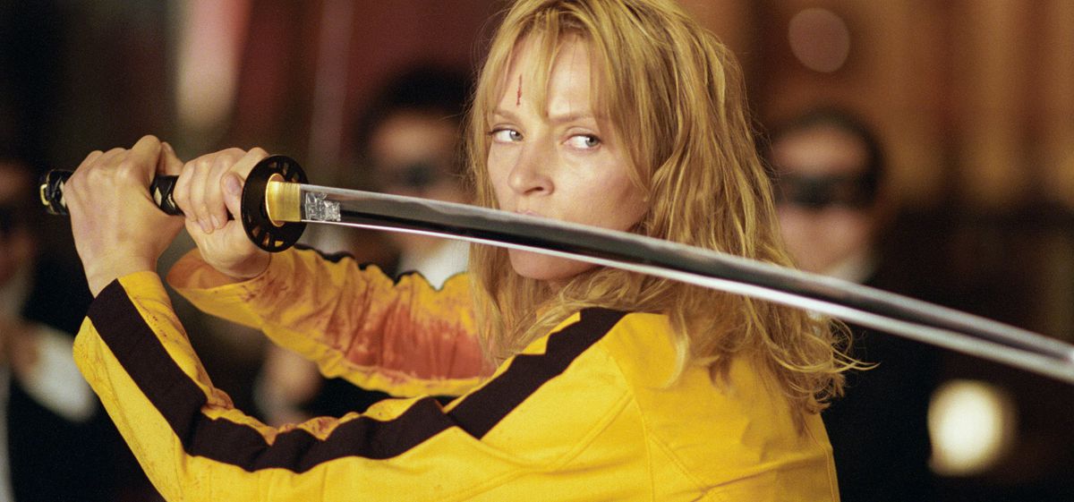 Vêtue d'une combinaison jaune, Beatrix pose avec son épée dans Kill Bill : Volume 1