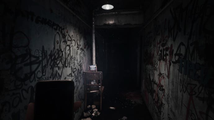 Silent Hill La capture d'écran du message court.  Un couloir jonché de détritus et couvert de graffitis dans une sorte de bâtiment abandonné.