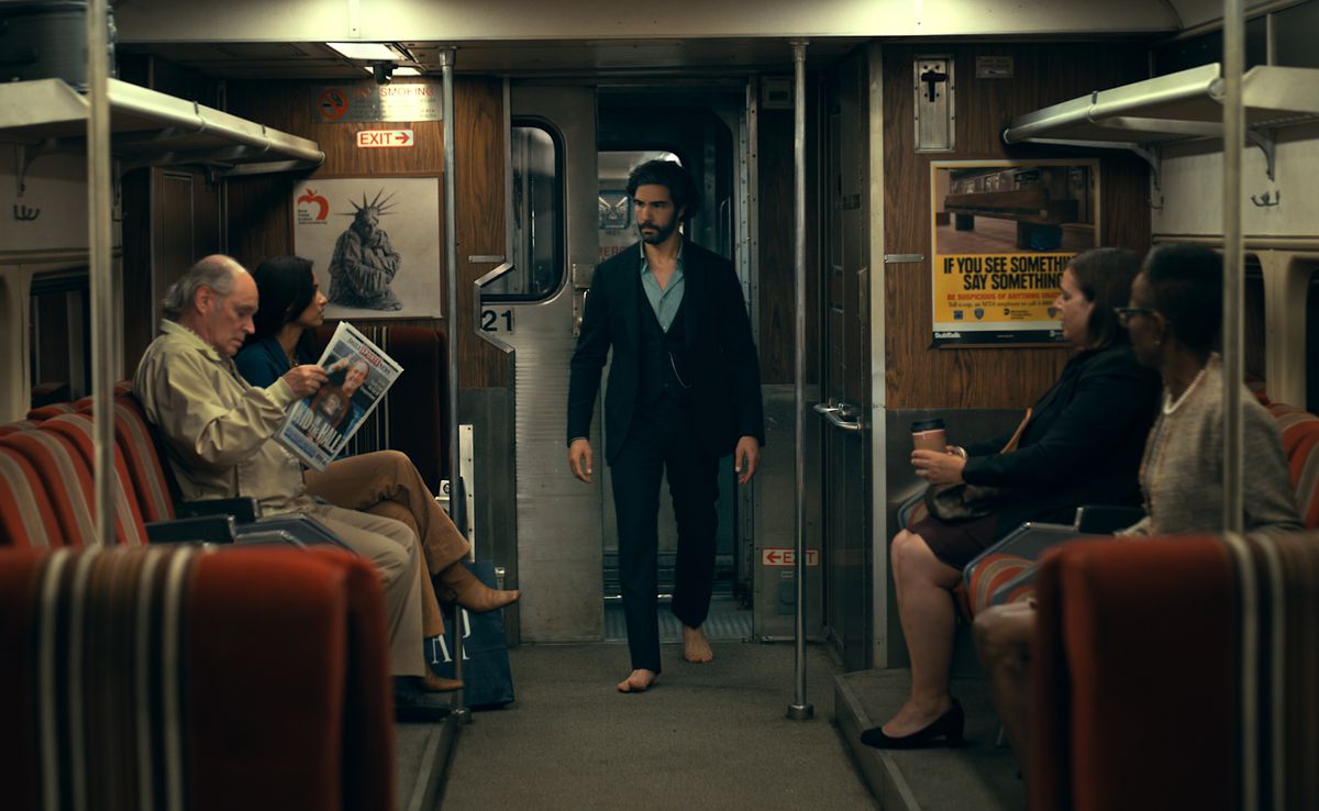 Ezekiel Sims (Tahar Rahim) traverse une rame de métro de New York, vêtu d'un costume, d'une chemise bleue et sans chaussures (ew, dans le MÉTRO ?!) dans Madame Web