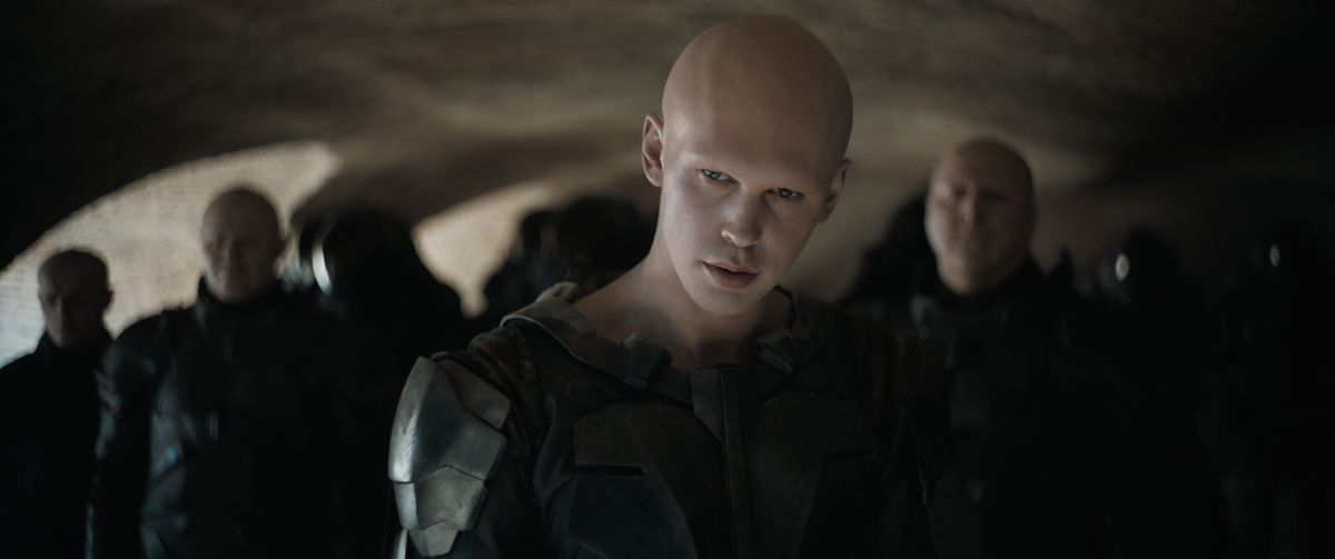 Austin Butler dans le rôle de Feyd-Rautha Harkonnen vêtu de noir avec un groupe de soldats derrière lui dans Dune : deuxième partie