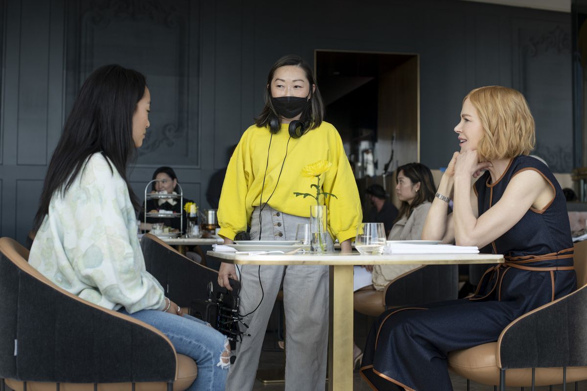 Lulu Wang debout à une table avec Ji-young Yoo et Nicole Kidman dans les coulisses d'Expats